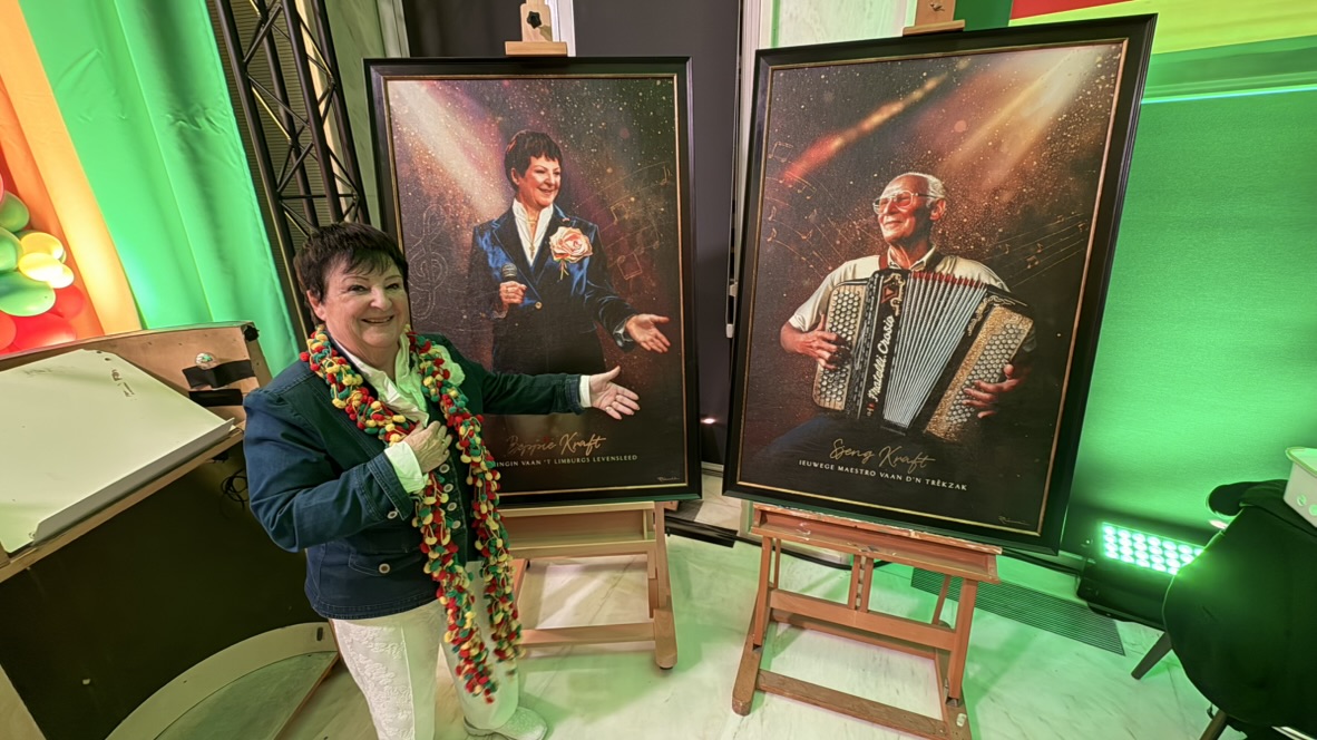 Beppie Kraft standing beside the portraits of herself and her father Sjeng Kraft