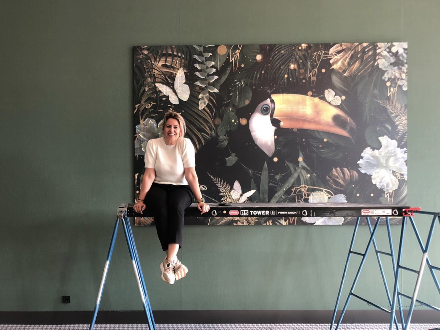 Ramona Nieuwenhuisen sitting on scaffolding in front of the large Toekan artwork
